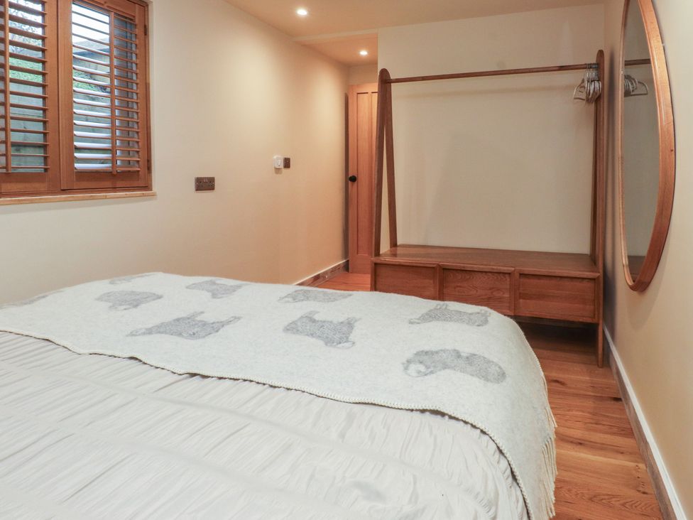 A bedroom with a bed and a mirror at Riverside Lodge Afonwen