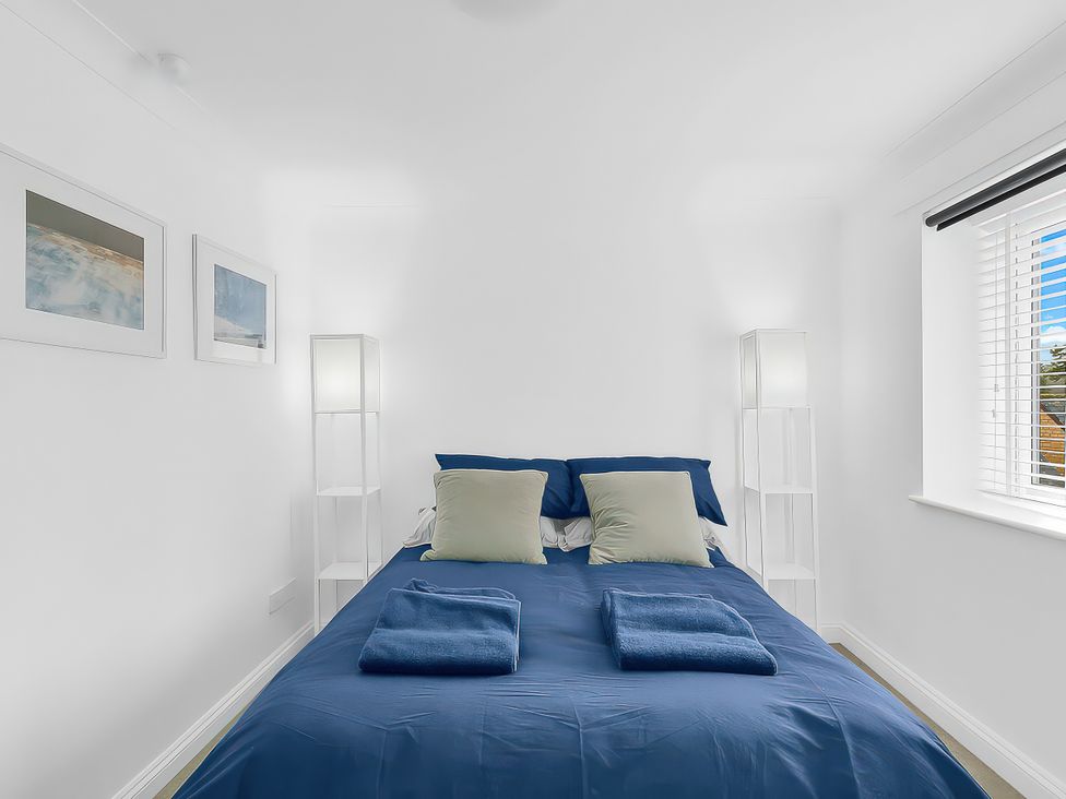 A bedroom with a bed and lamps at 40 Raleigh Court, Sherborne