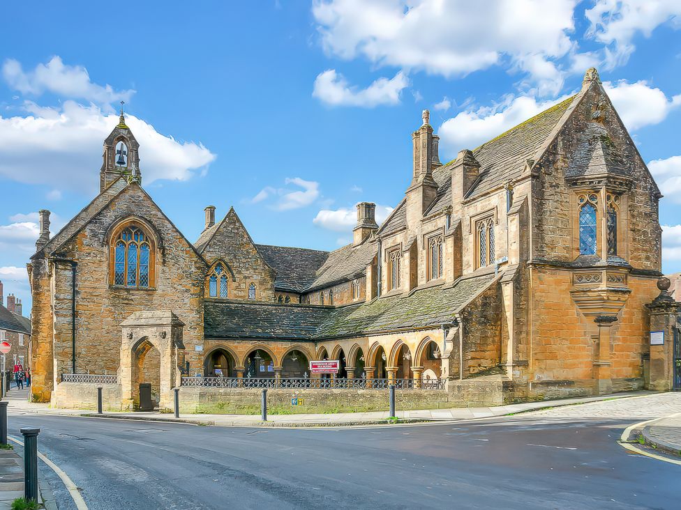 A historic building with arched windows and a tower at 40 Raleigh Court Sherborne