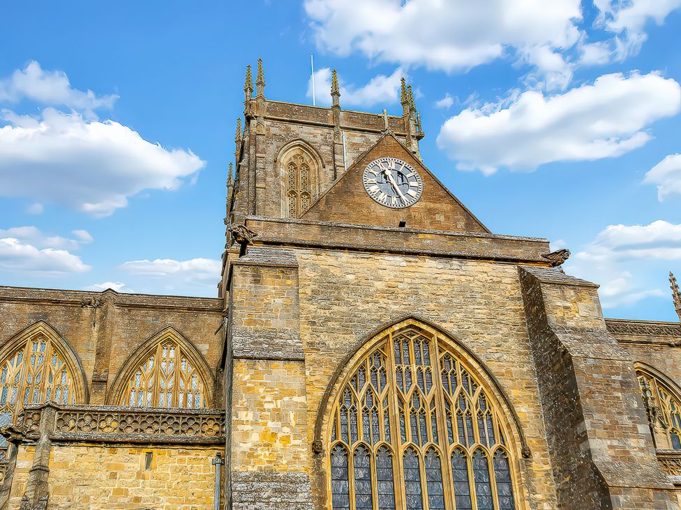A church building with an arched window and clock tower at 40 Raleigh Court Sherborne