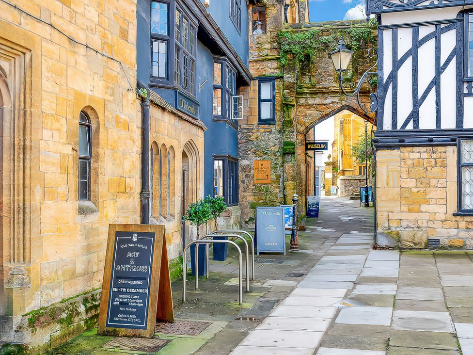 A street with stone buildings and signs at Old Yarn Mills in Sherborne