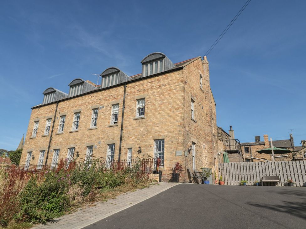 An outdoor view of a building with windows and a garden at The Sea Chest in Alnmouth