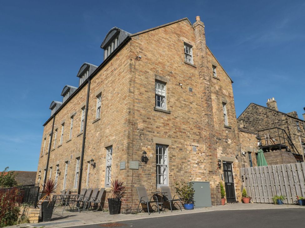An outdoor view of a building with seating and planters at The Sea Chest in Alnmouth