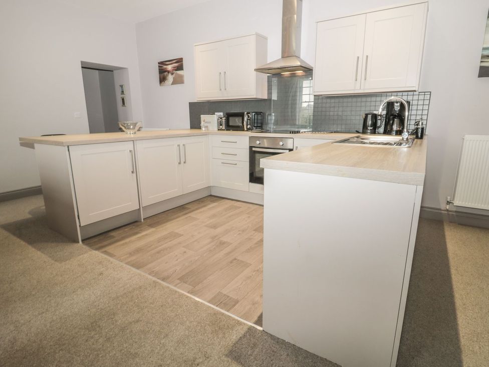 A kitchen with cabinets and appliances at The Sea Chest in Alnmouth