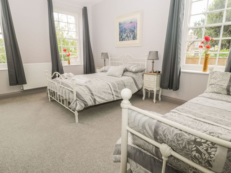 A bedroom with two beds and a bedside table at The Sea Chest in Alnmouth