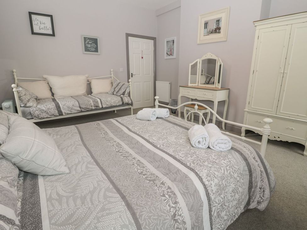 A bedroom with a bed and a couch at The Sea Chest in Alnmouth