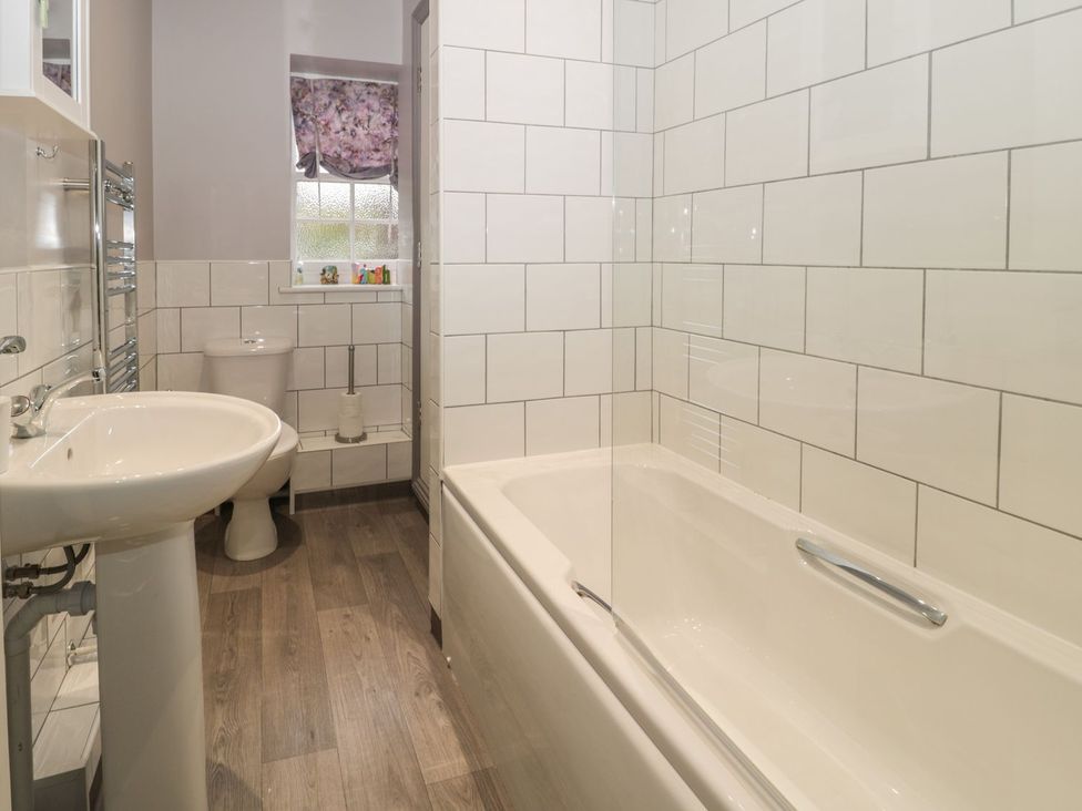 A bathroom with a bathtub, toilet, and sink at The Sea Chest in Alnmouth