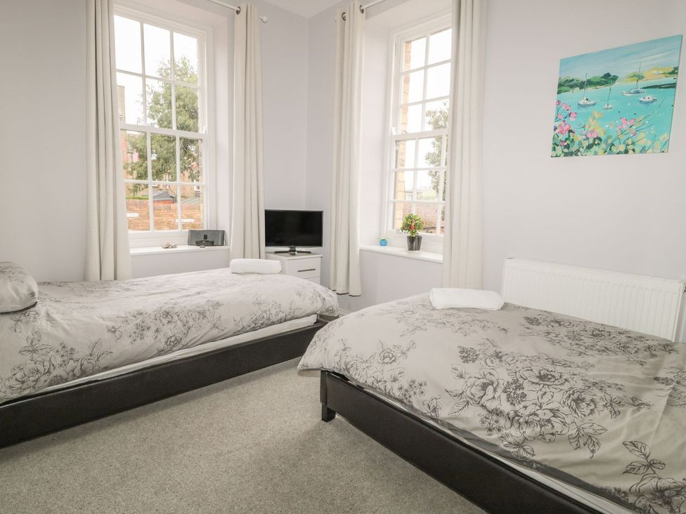 A bedroom with two beds and a television at The Sea Chest in Alnmouth