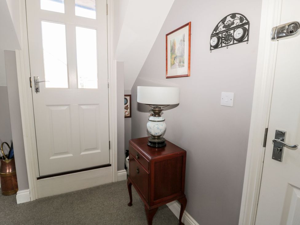 A hallway with a lamp and side table at Sunset Point in Alnwick
