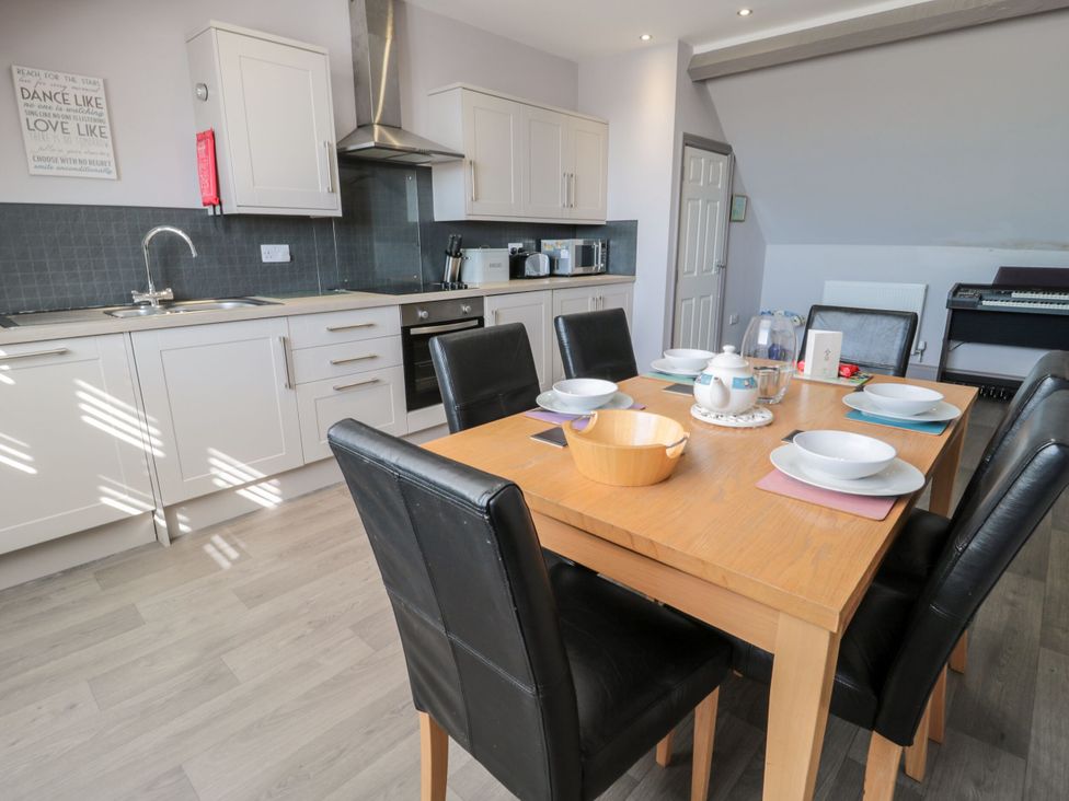 A kitchen with a dining table set for meals at Sunset Point in Alnwick