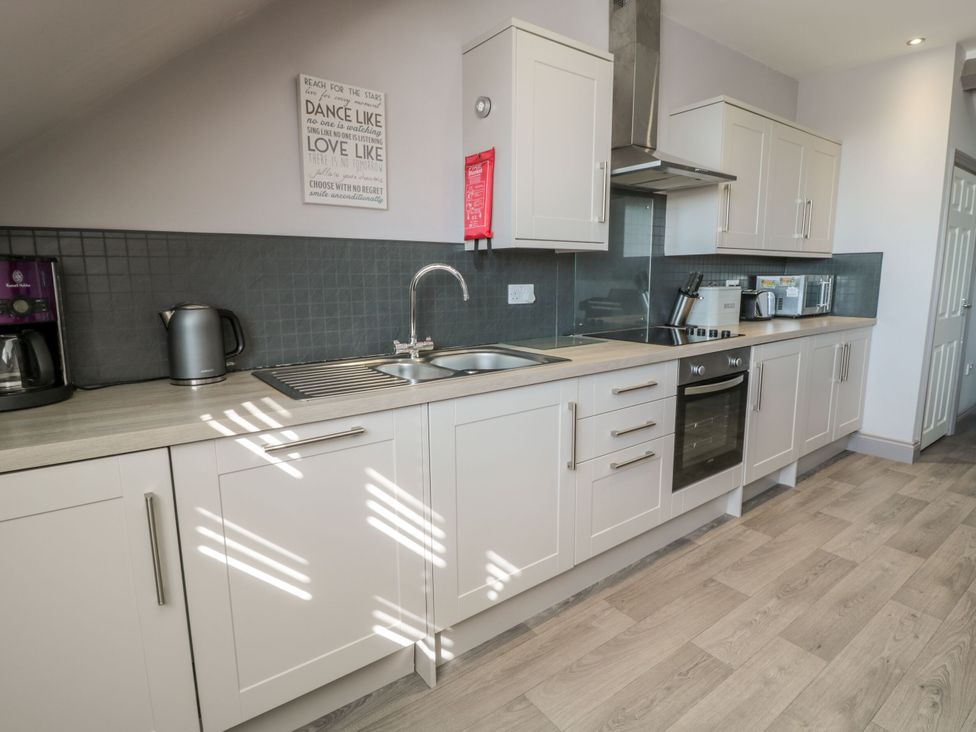 A kitchen with a sink and kitchen appliances at Sunset Point in Alnwick