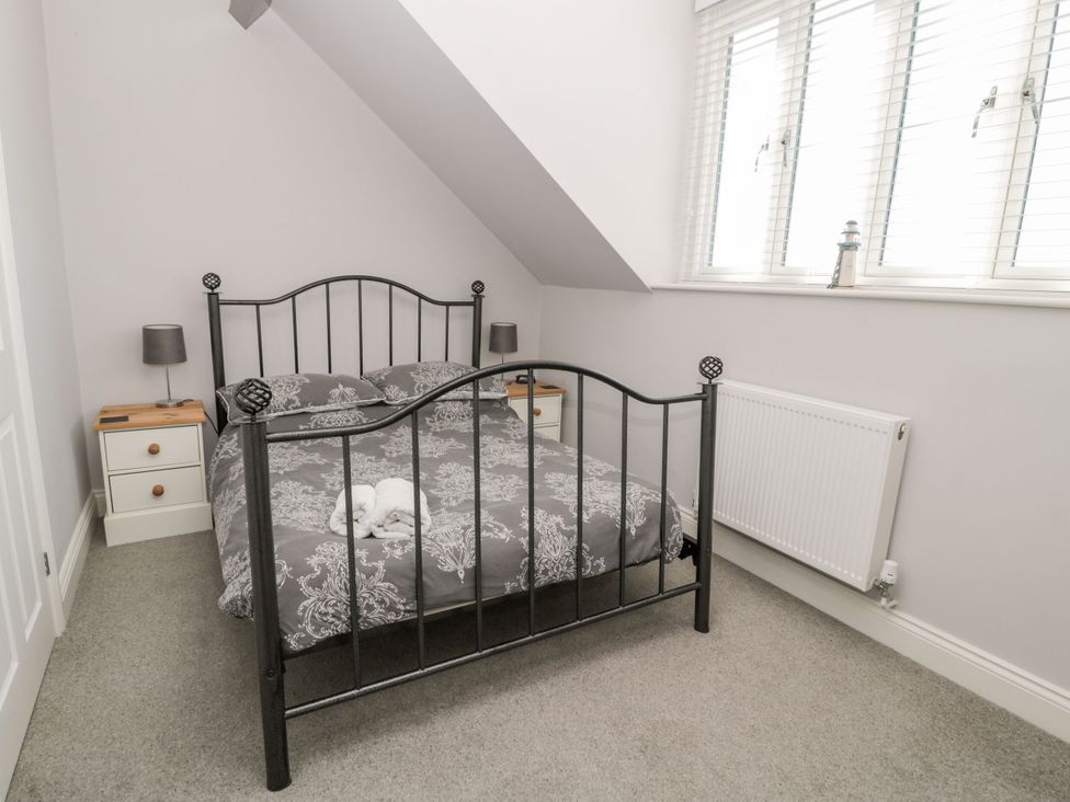 A bedroom with a bed and nightstands at Sunset Point in Alnwick