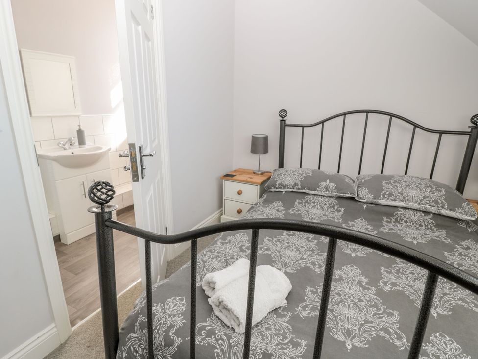 A bedroom with a bed and en suite bathroom at Sunset Point in Alnwick