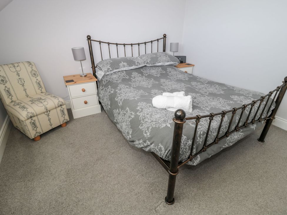 A bedroom with a bed and a chair at Sunset Point in Alnwick