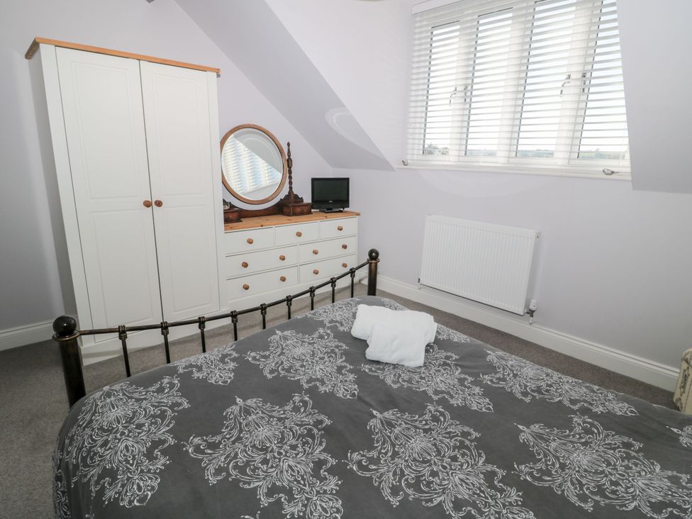 A bedroom with a bed and a dresser at Sunset Point in Alnwick