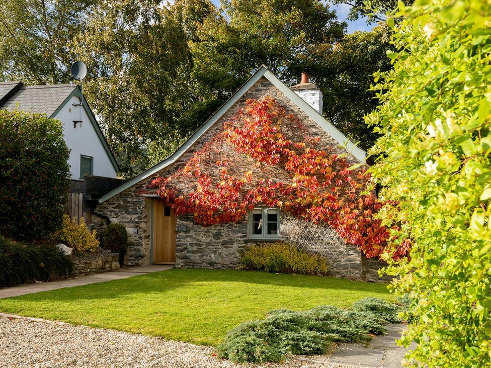 A cottage with a garden and gravel path at Ghillies Cottage Llandrillo