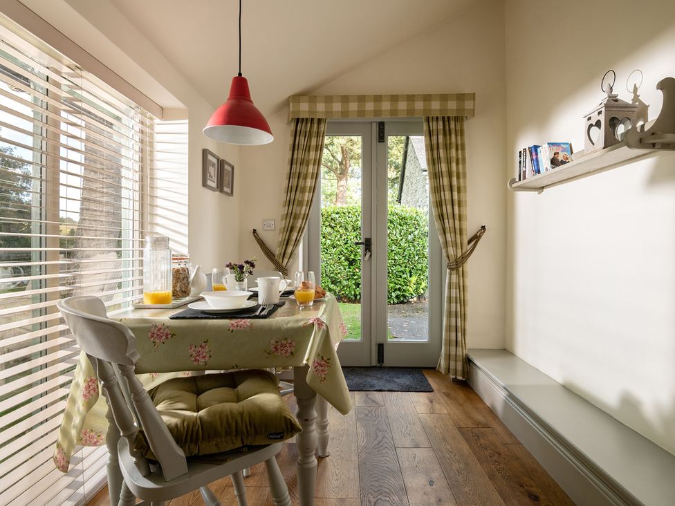 A dining area with a table set for breakfast at Ghillies Cottage in Llandrillo