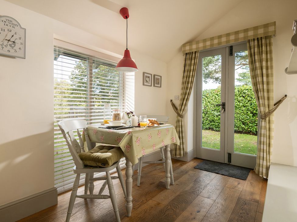 A dining room with a table and chairs at Ghillies Cottage in Llandrillo