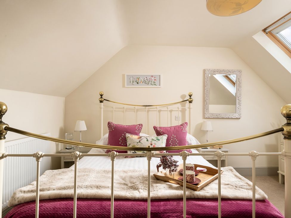 A bedroom with a bed and decorative items at Ghillies Cottage Llandrillo