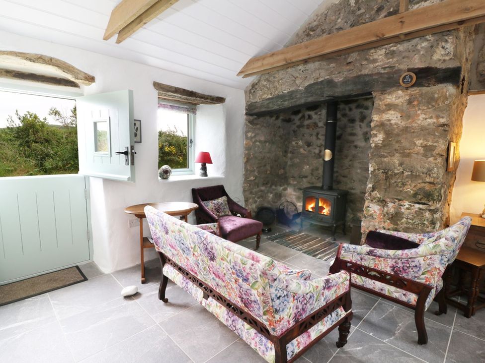 A living room with a fireplace and two chairs at Rhos Y Clegryn in Goodwick