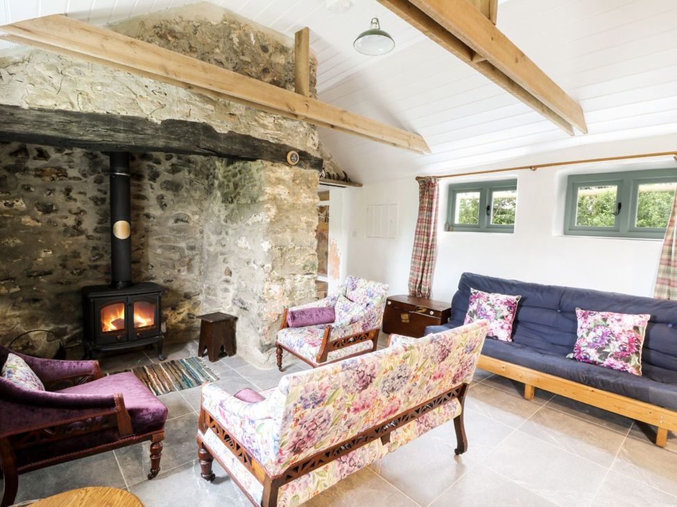 A living room with a fireplace and seating at Rhos Y Clegryn in Goodwick