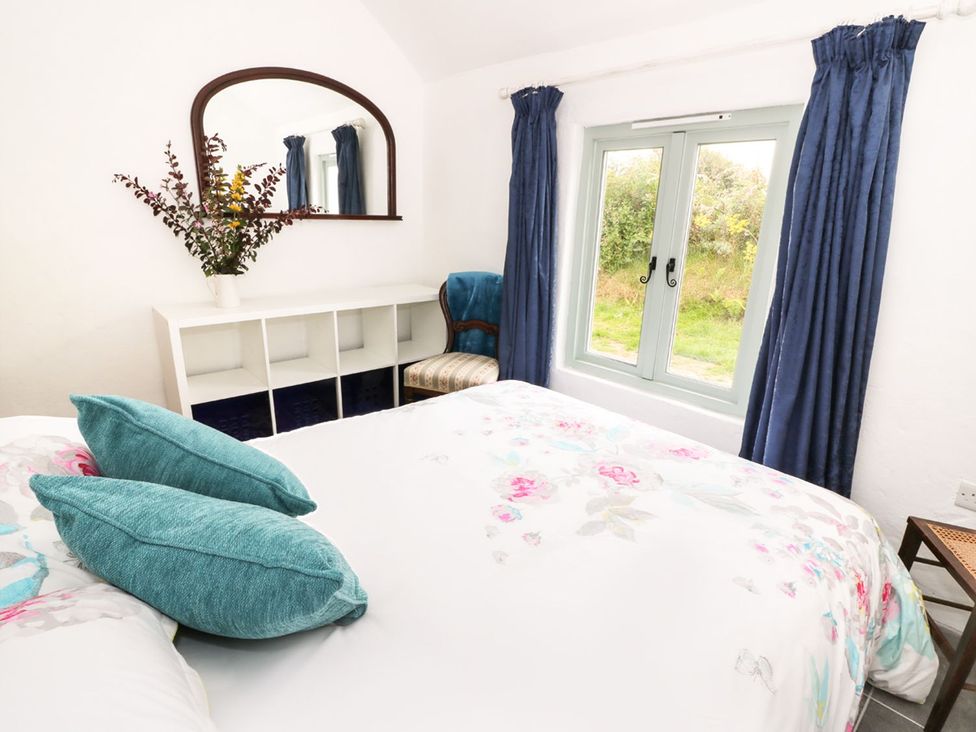 A bedroom with a bed and window at Rhos Y Clegryn Goodwick