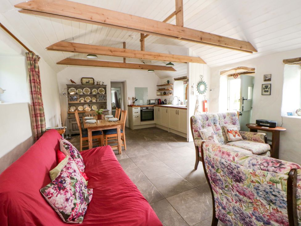 A living room with a sofa and dining area at Rhos Y Clegyrn Goodwick