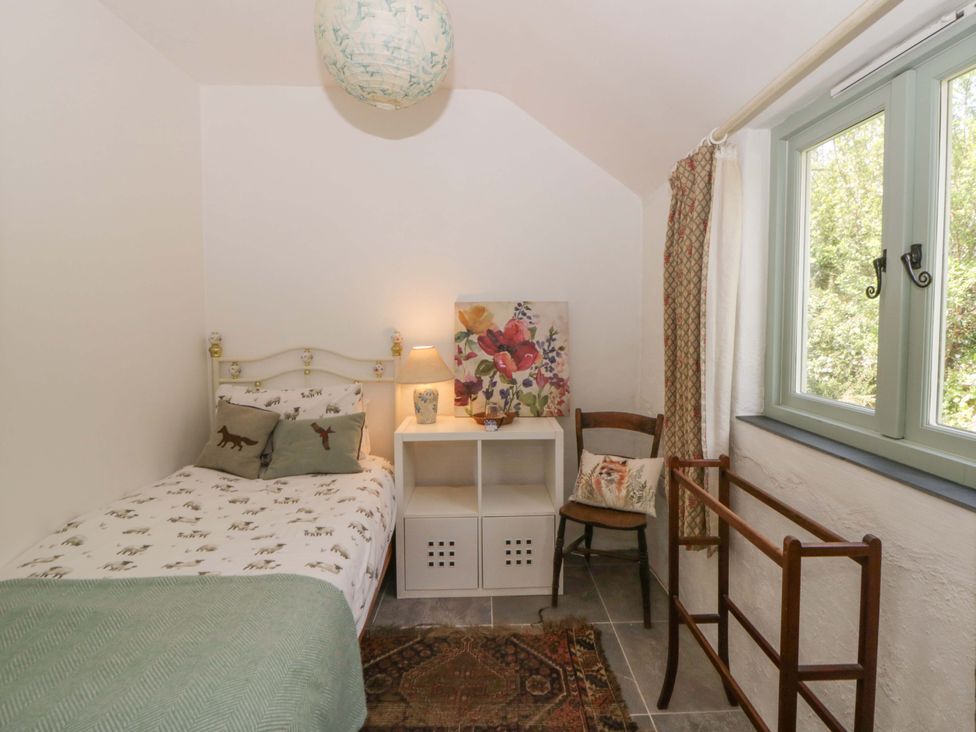 A bedroom with a bed and a chair at Rhos Y Clegyrn Goodwick