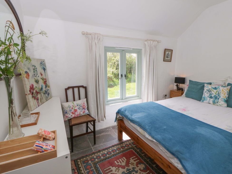 A bedroom with a bed and chair at Rhos Y Clegyrn Goodwick