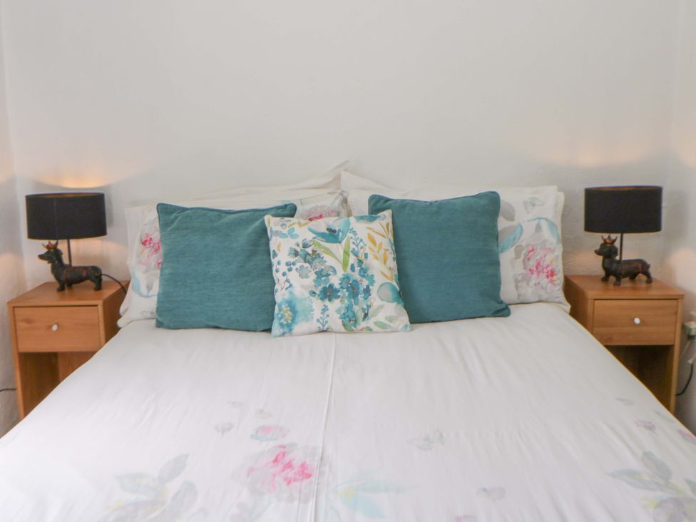A bed with pillows and lamps in Rhos Y Clegyrn Goodwick