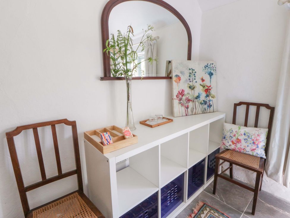 An entryway with a mirror and storage unit at Rhos Y Clegyrn Goodwick