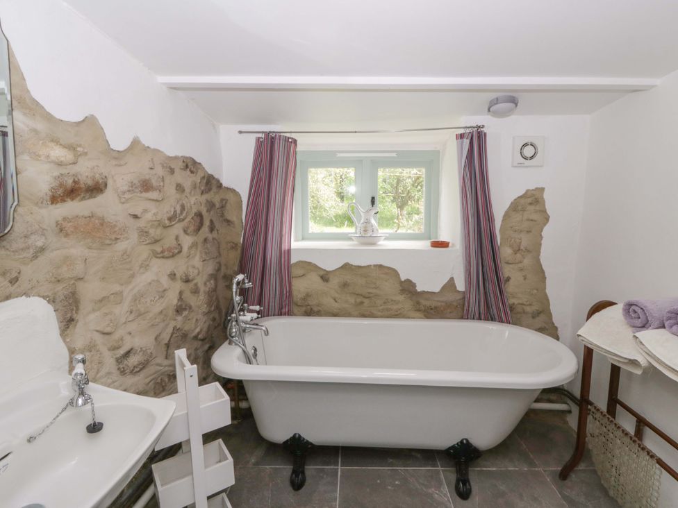 A bathroom with a bathtub and sink at Rhos Y Clegyrn Goodwick