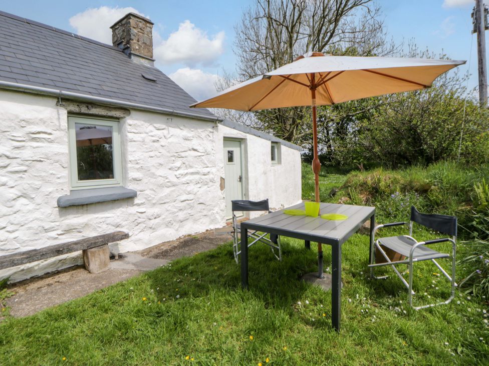 An outdoor table and chairs with an umbrella at Rhos Y Clegyrn Goodwick