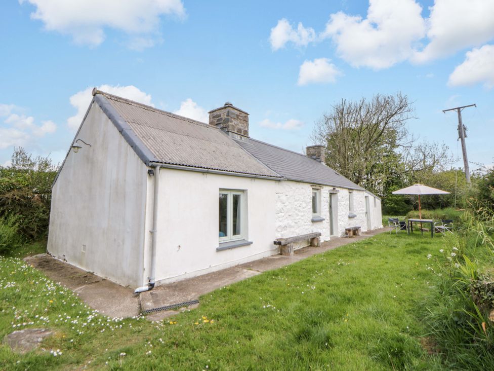 A cottage with a garden and outdoor seating area at Rhos Y Clegyrn in Goodwick
