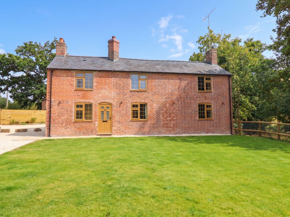 A house with a brick exterior and lawn at Bridge Farm Pontyblew near Chirk