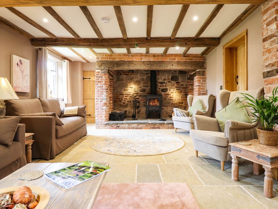 A living room with sofa and armchairs at Bridge Farm Pontyblew near Chirk