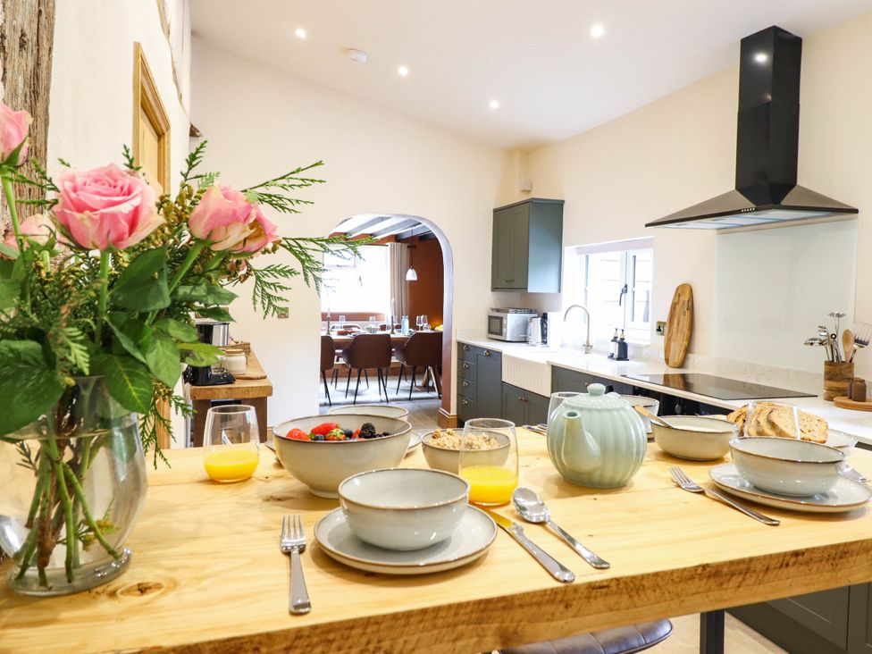 A kitchen with a dining table set for breakfast at Bridge Farm in Pontyblew near Chirk