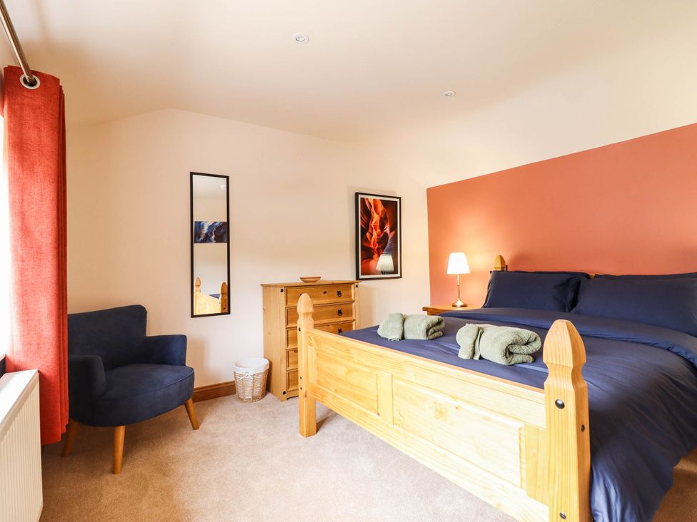 A bedroom with a bed and chair at Bridge Farm Pontyblew near Chirk