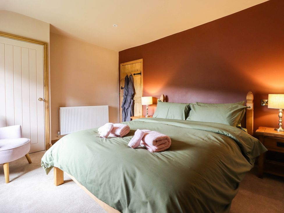 A bedroom with a bed and bedside lamps at Bridge Farm in Pontyblew near Chirk