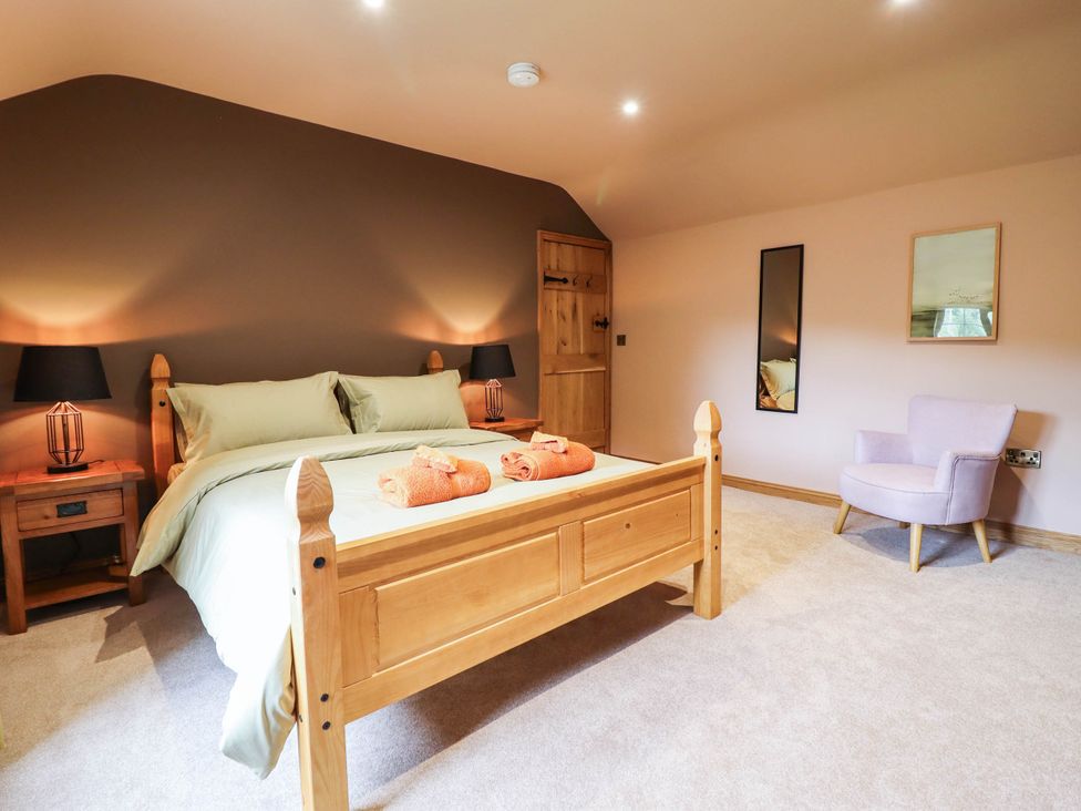 A bedroom with a bed and nightstand at Bridge Farm Pontyblew near Chirk