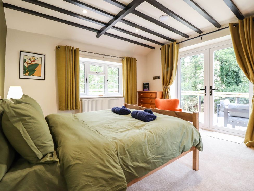 A bedroom with a bed and window at Bridge Farm Pontyblew near Chirk