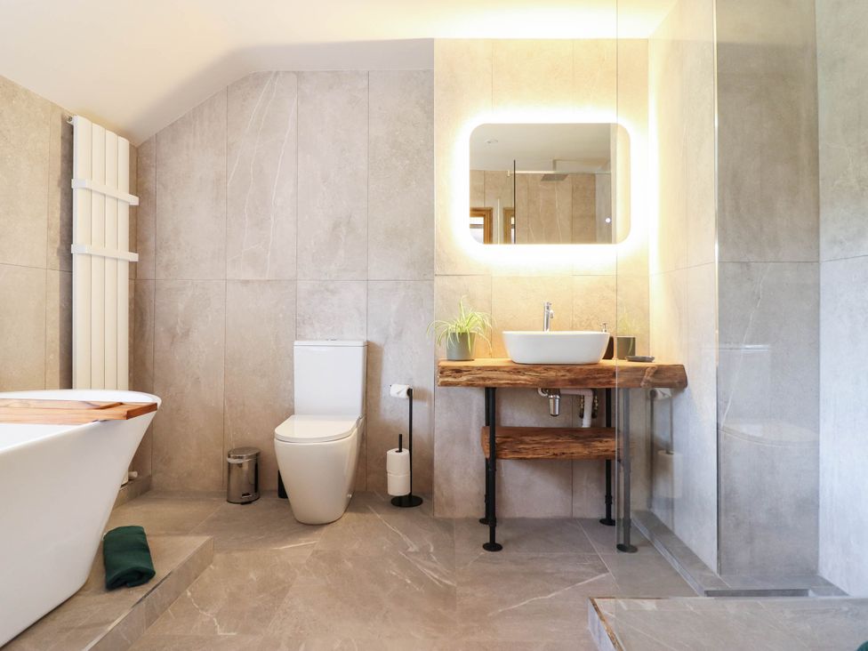 A bathroom with a bathtub, toilet, and sink at Bridge Farm in Pontyblew near Chirk