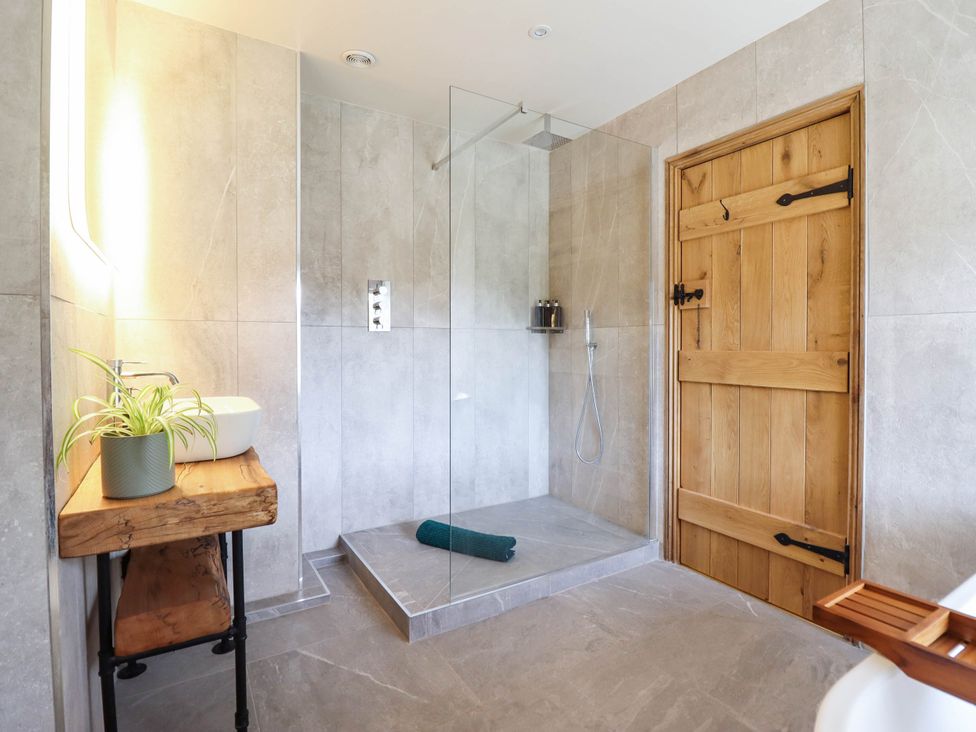 A bathroom with a shower and sink at Bridge Farm Pontyblew near Chirk