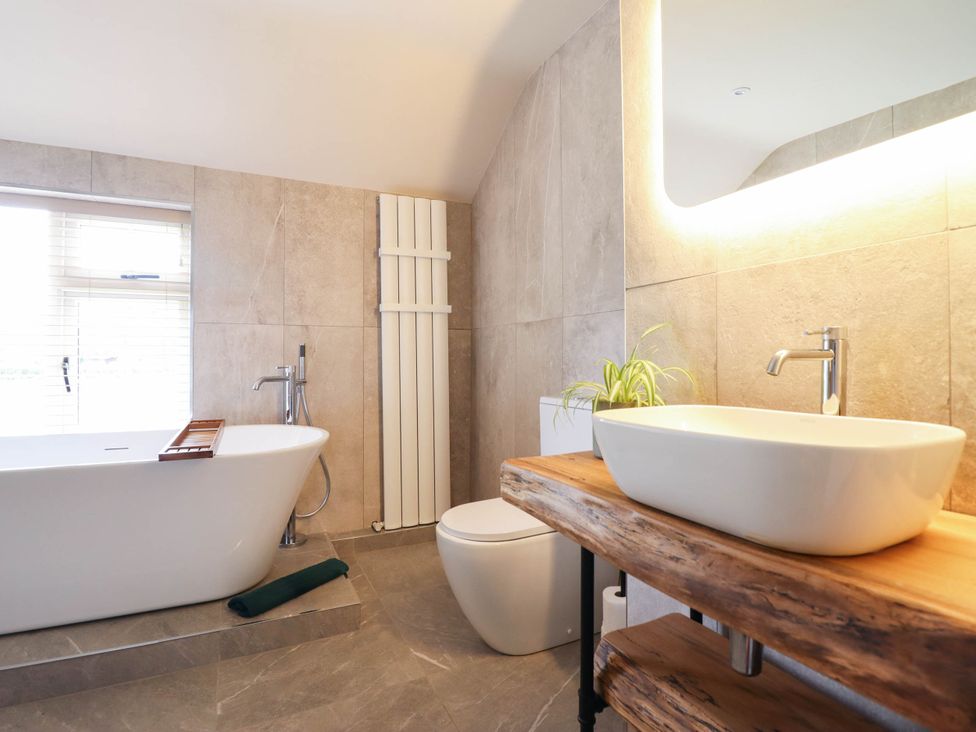 A bathroom with a bathtub, toilet, and sink at Bridge Farm Pontyblew near Chirk