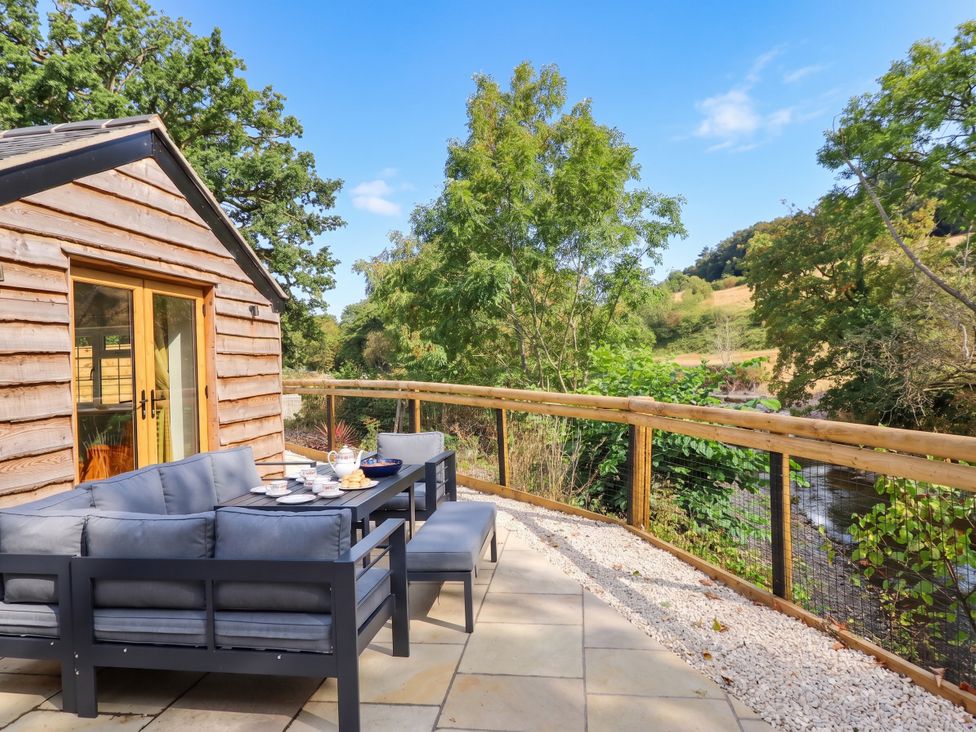 An outdoor seating area with a table and couch at Bridge Farm Pontyblew near Chirk