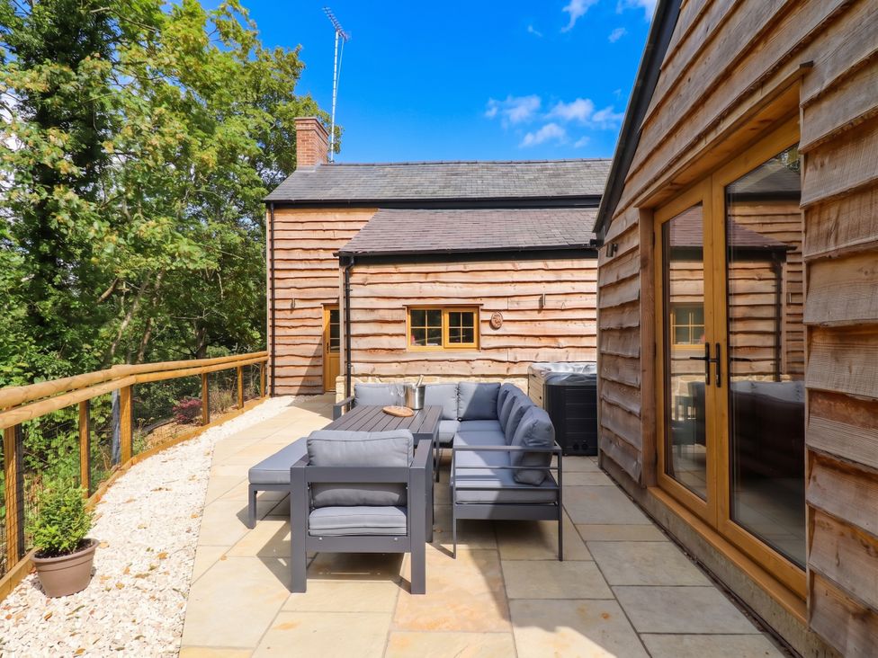 An outdoor patio with seating and a table at Bridge Farm Pontyblew near Chirk
