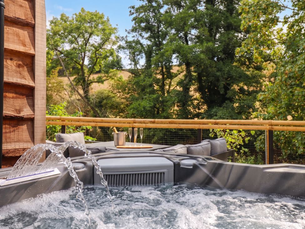 A hot tub with champagne glasses on a table at Bridge Farm in Pontyblew near Chirk