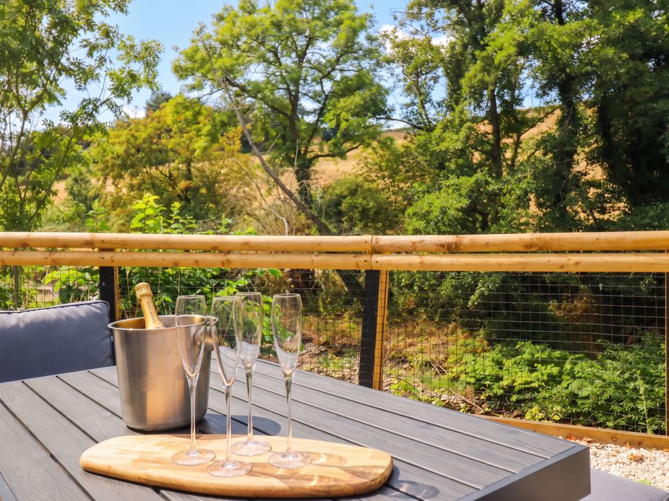 An outdoor seating area with an ice bucket and glasses at Bridge Farm Pontyblew near Chirk