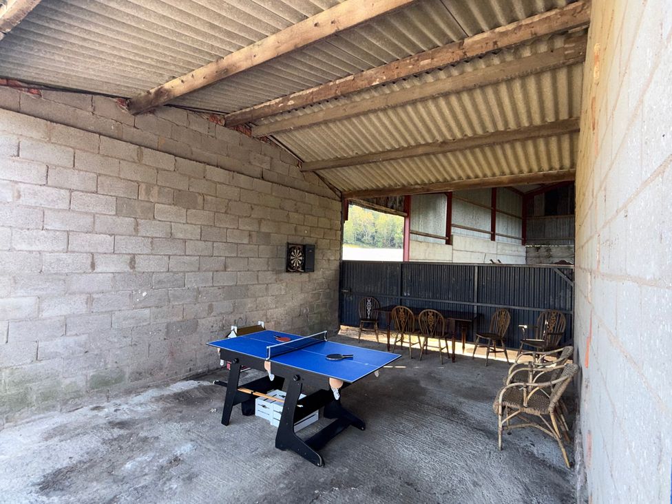 An outdoor area with a ping pong table and chairs at Bridge Farm Pontyblew near Chirk