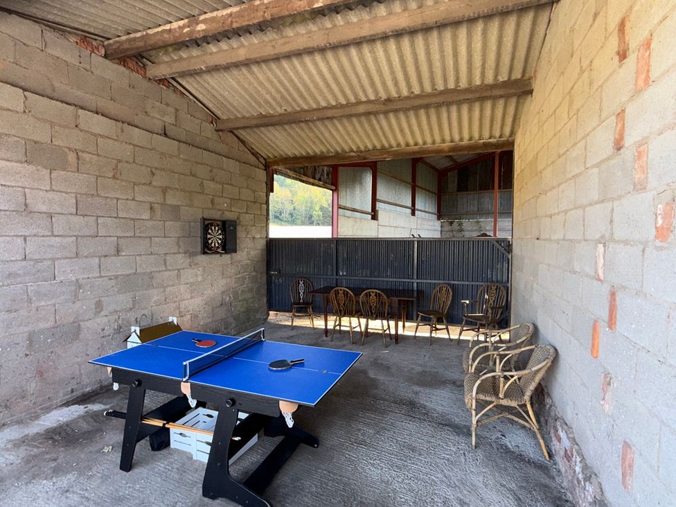An outdoor area with a table tennis table and dartboard at Bridge Farm Pontyblew near Chirk